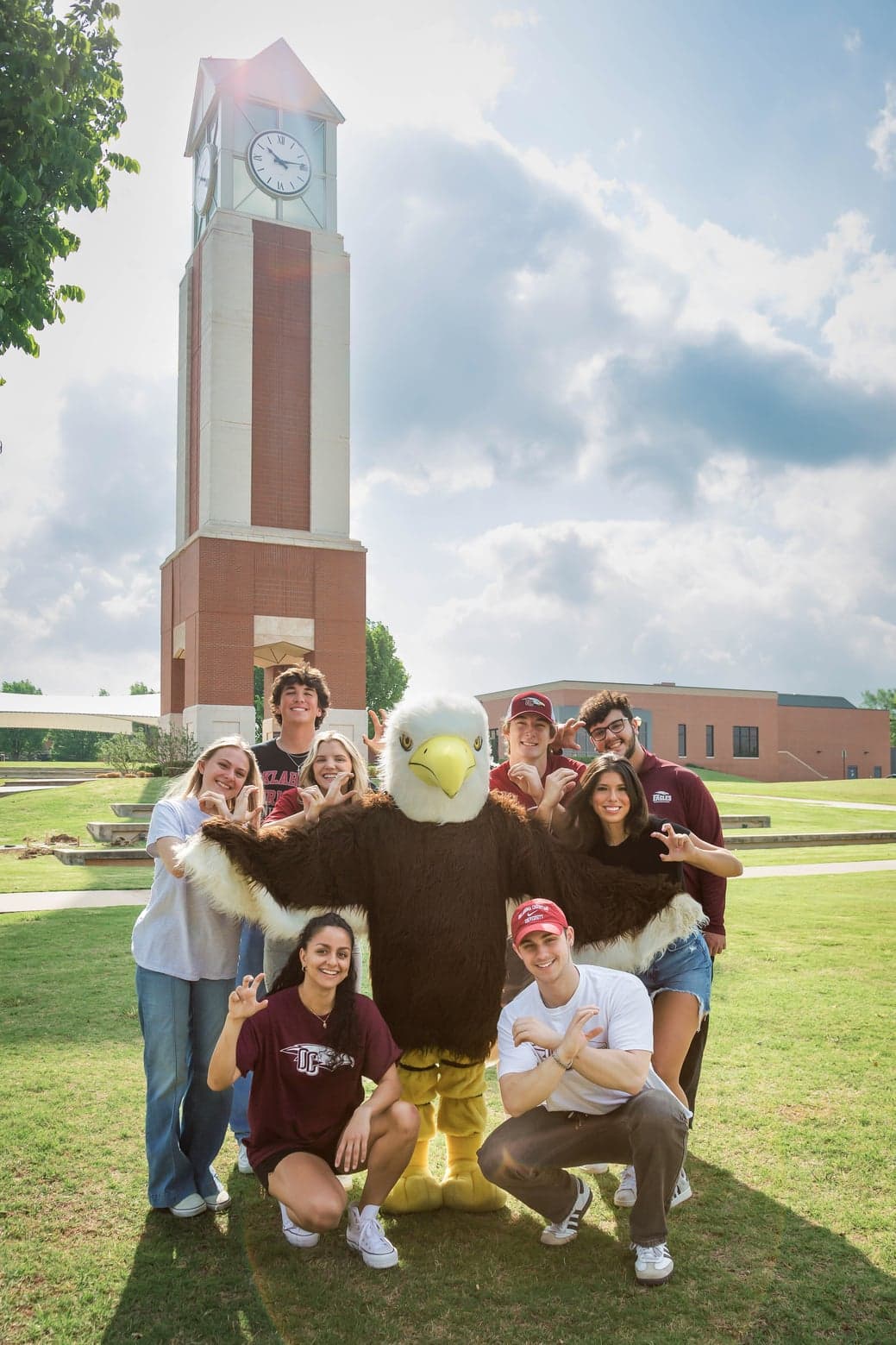 Students pose with Ike the Eagle in front of the clocktower on OC's campus.
